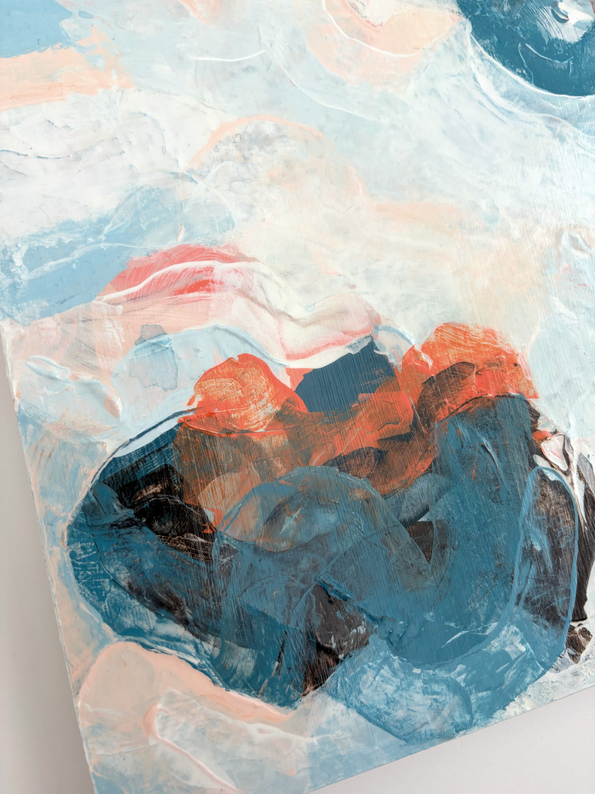 Abstract panel painting with textured impasto brushstrokes in light blue, white, peach, and dark blue, with a central dark blue and orange form.